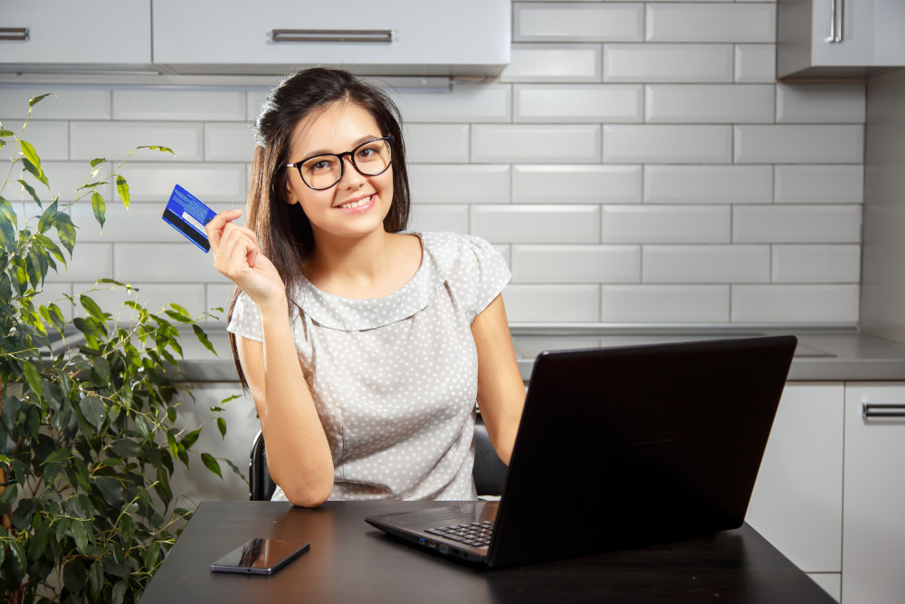 Happy woman shopping online with a credit card and laptop